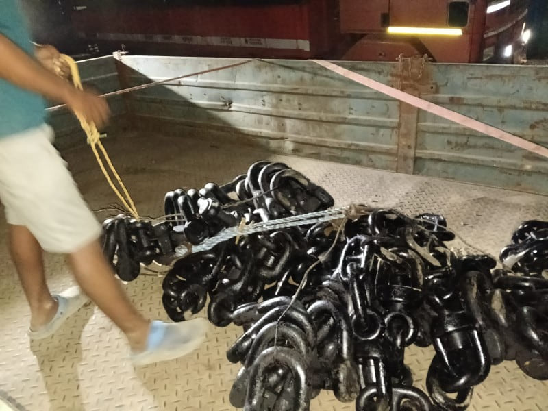 Stud link chain stacked in crates across the stockyard