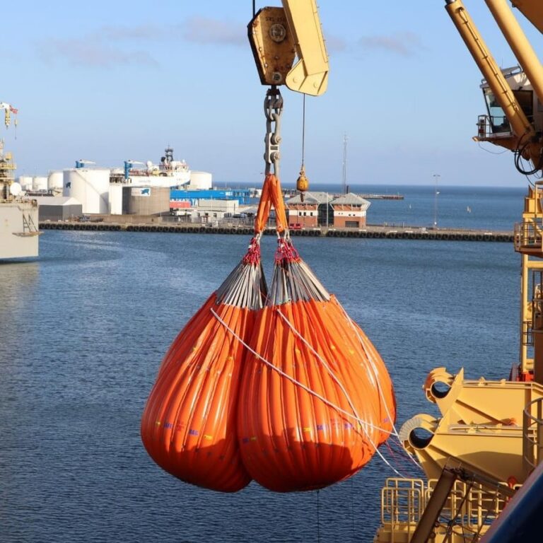 Orange water bags under proof load at a quayside test
